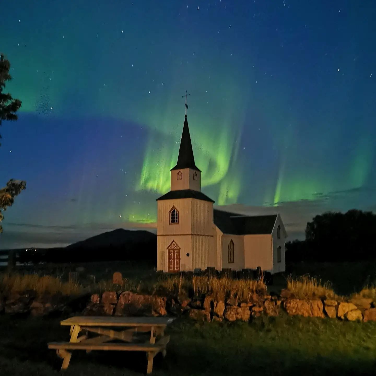 tradisjonell kirke med nordlys himmel over seg