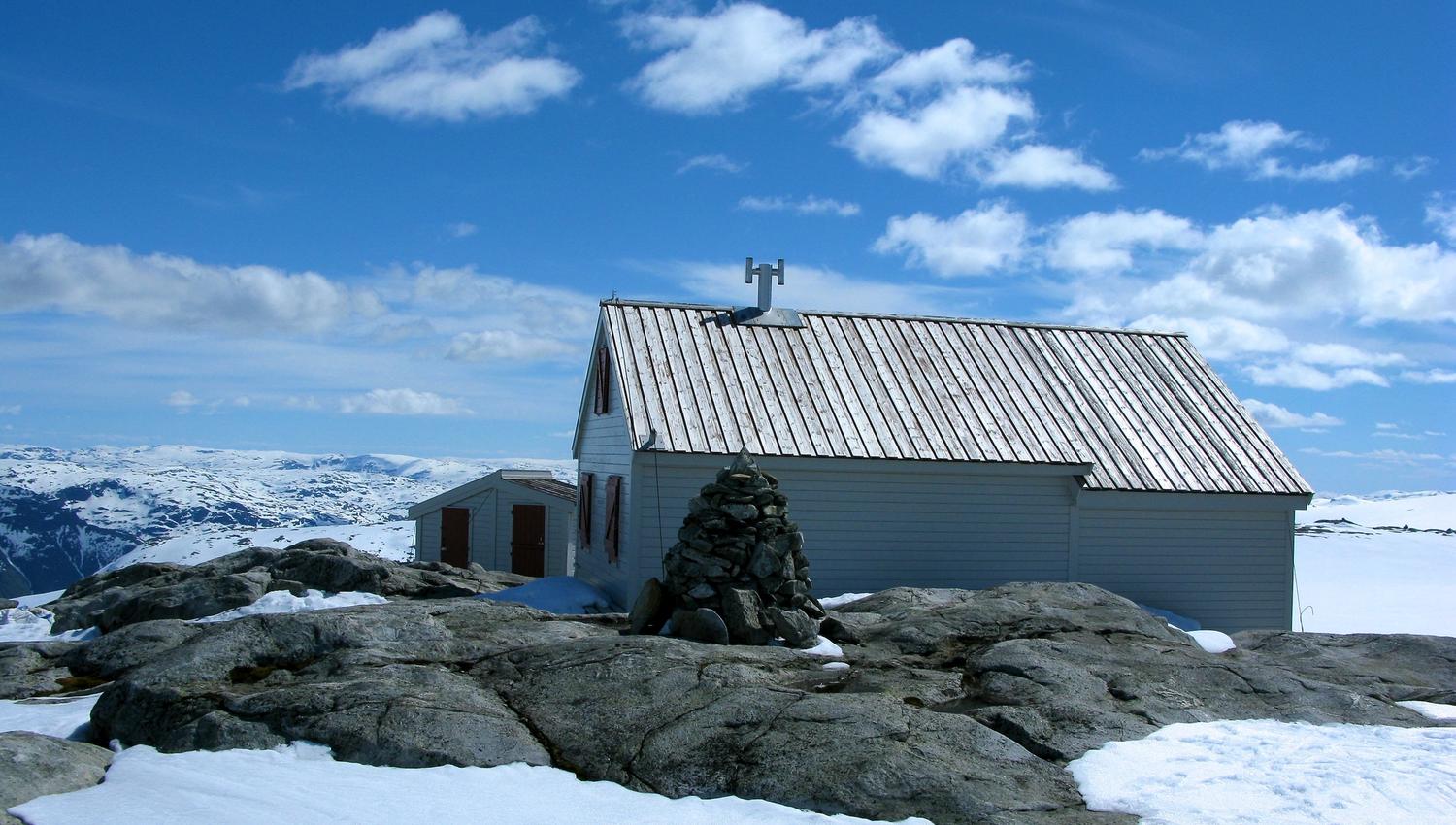 The Holmaskjer cabin standing on a snowy mountain plateau in Hardanger, with views towards the Folgefonna glacier.