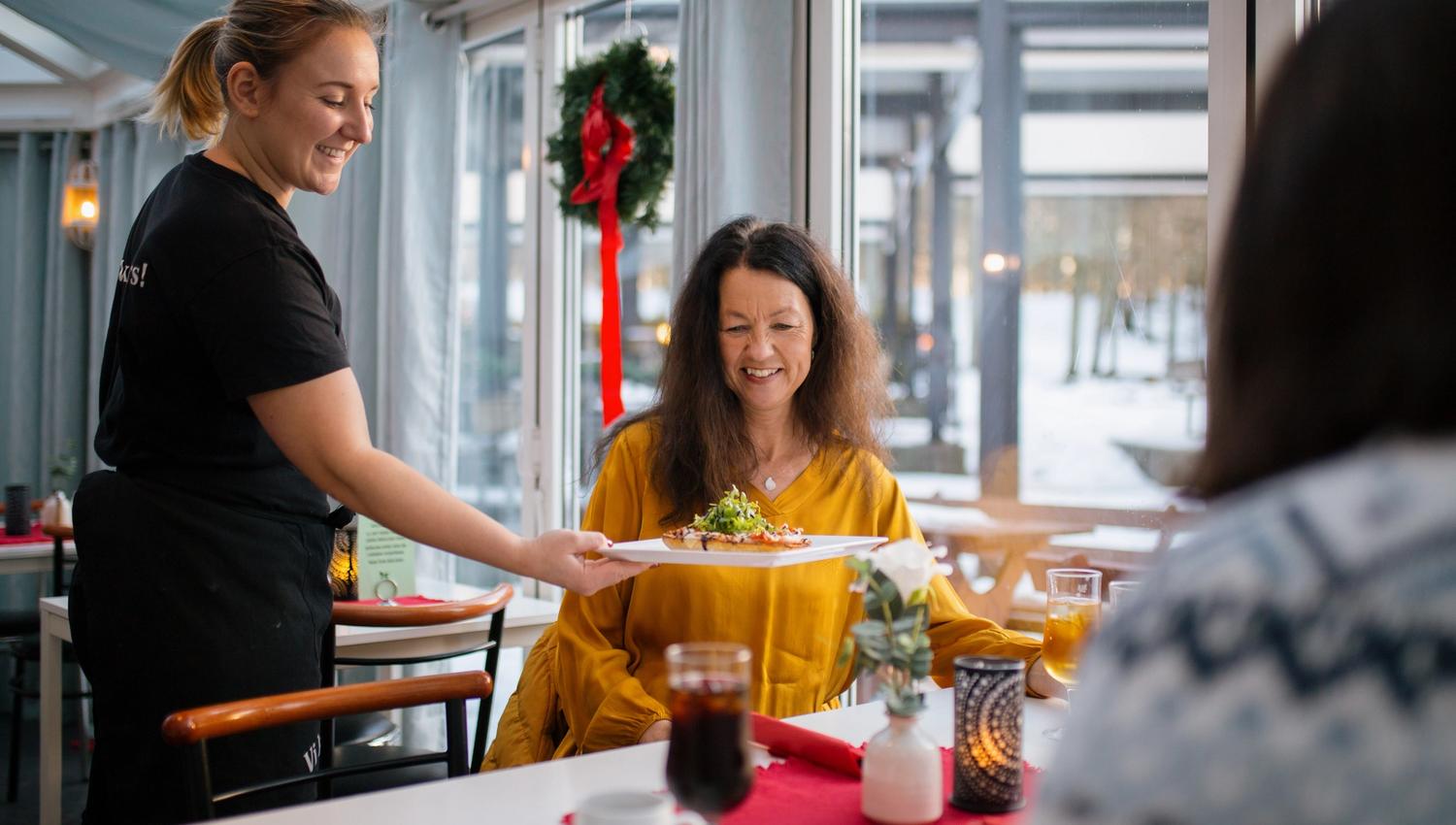 Waiter serves food on the table