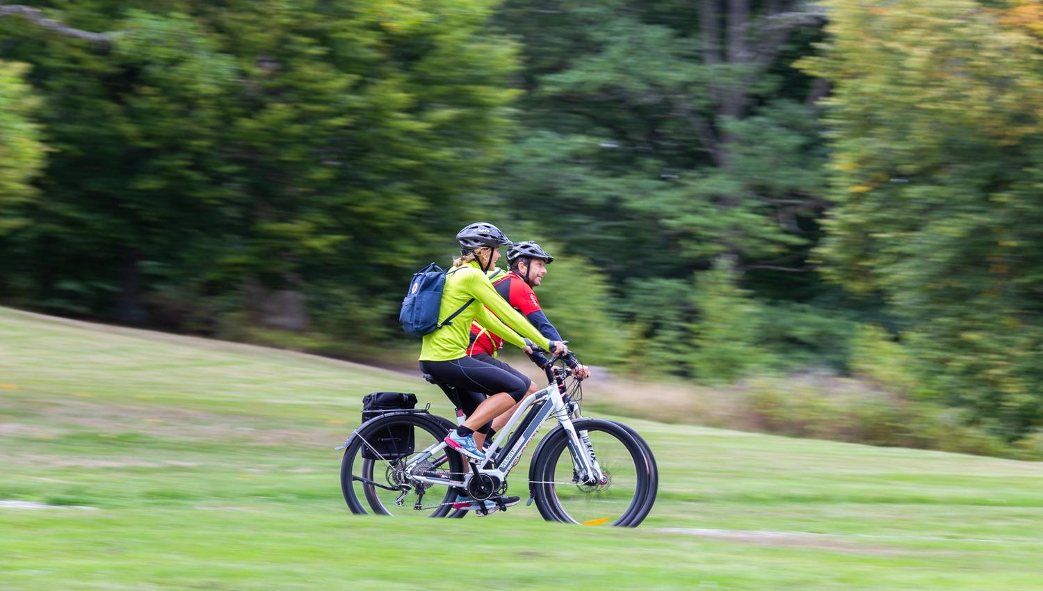 a couple going by bike in a park