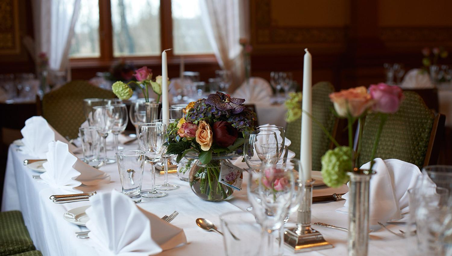 Table set with white cloth and flowers