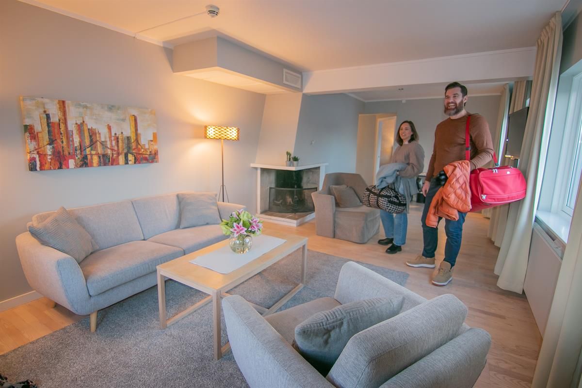 Family in a modern hotel room with a seating area.