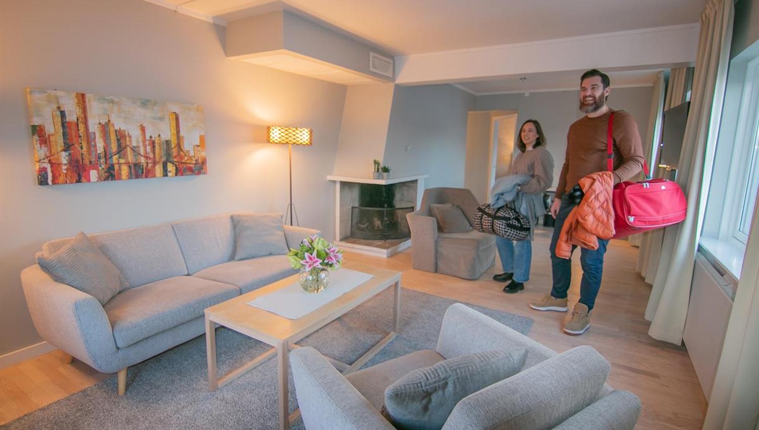 Family in a modern hotel room with a seating area.