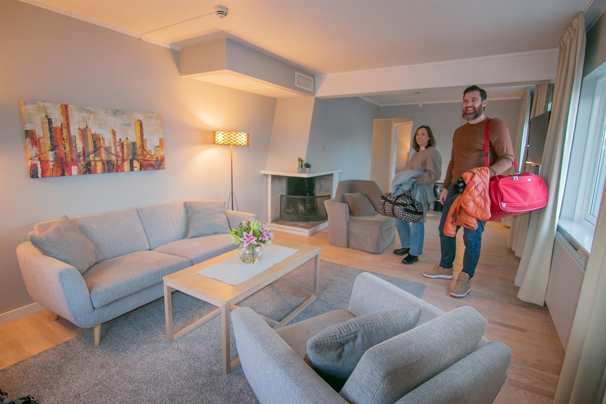 Hotell i Hamar. Familie i moderne hotellrom med sittegruppe.