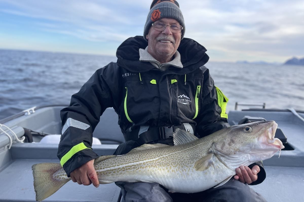 A person holding a large fish on a boat