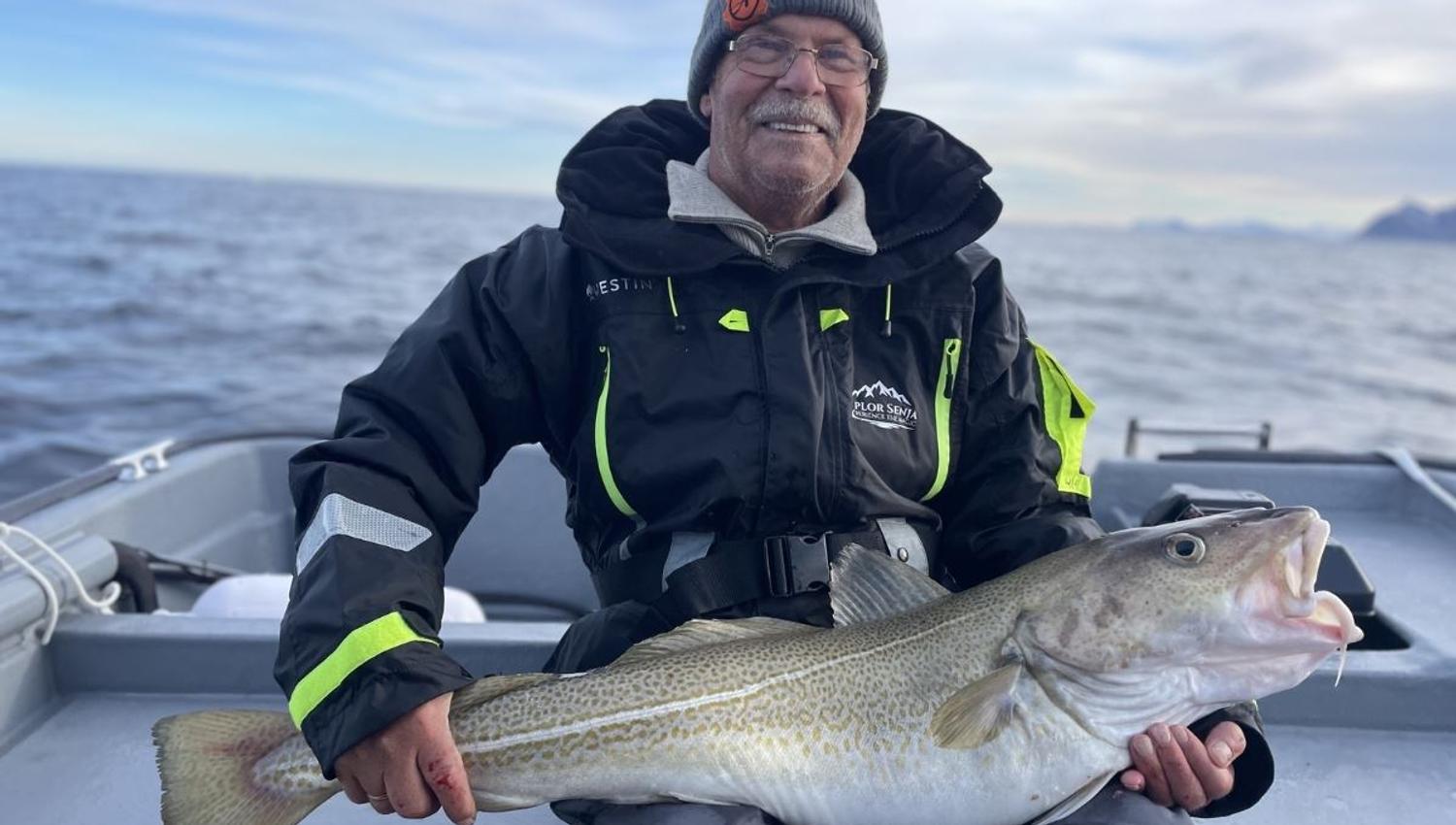 A person holding a large fish on a boat