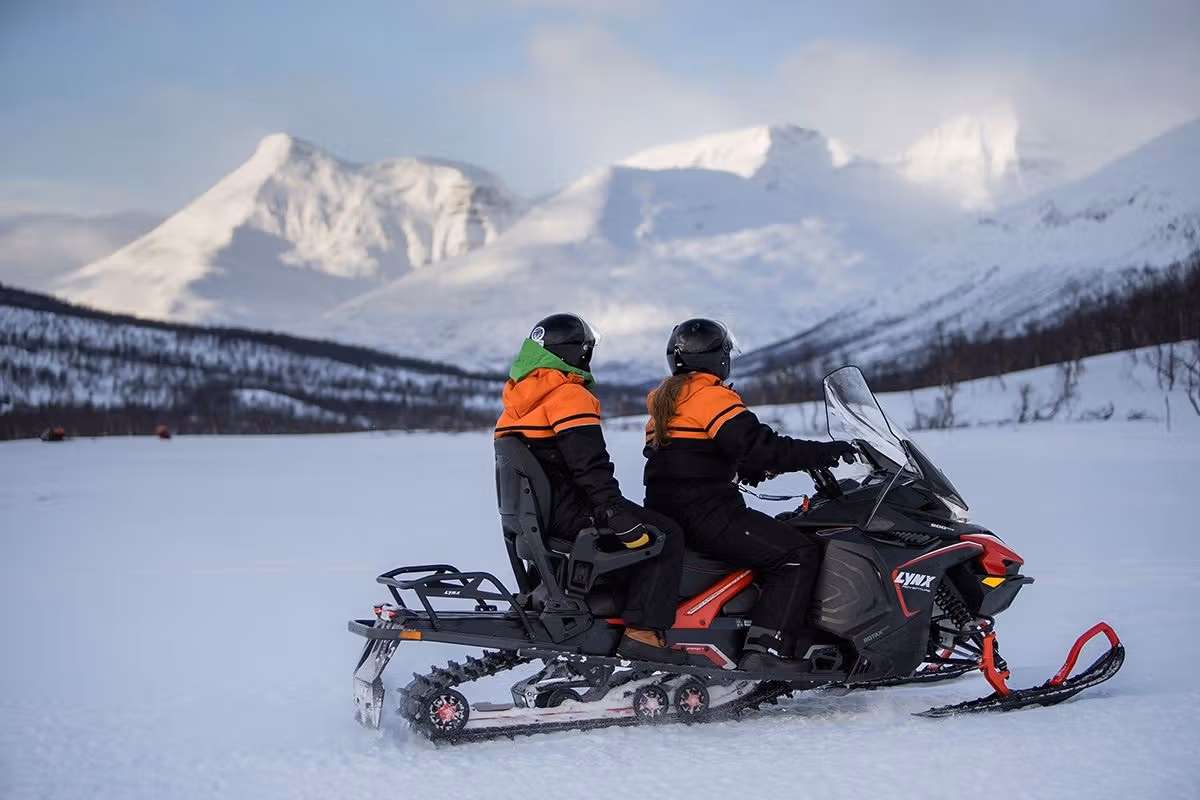 Gjester ser ut over de vakre fjellene fra snøskuteren