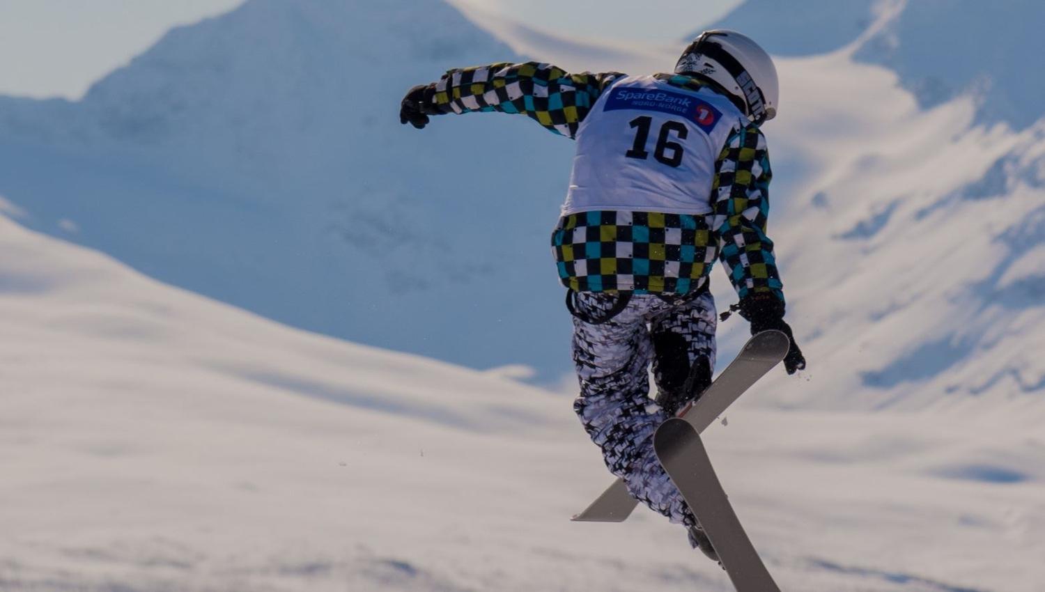 A skier does a high jump and a cool trick