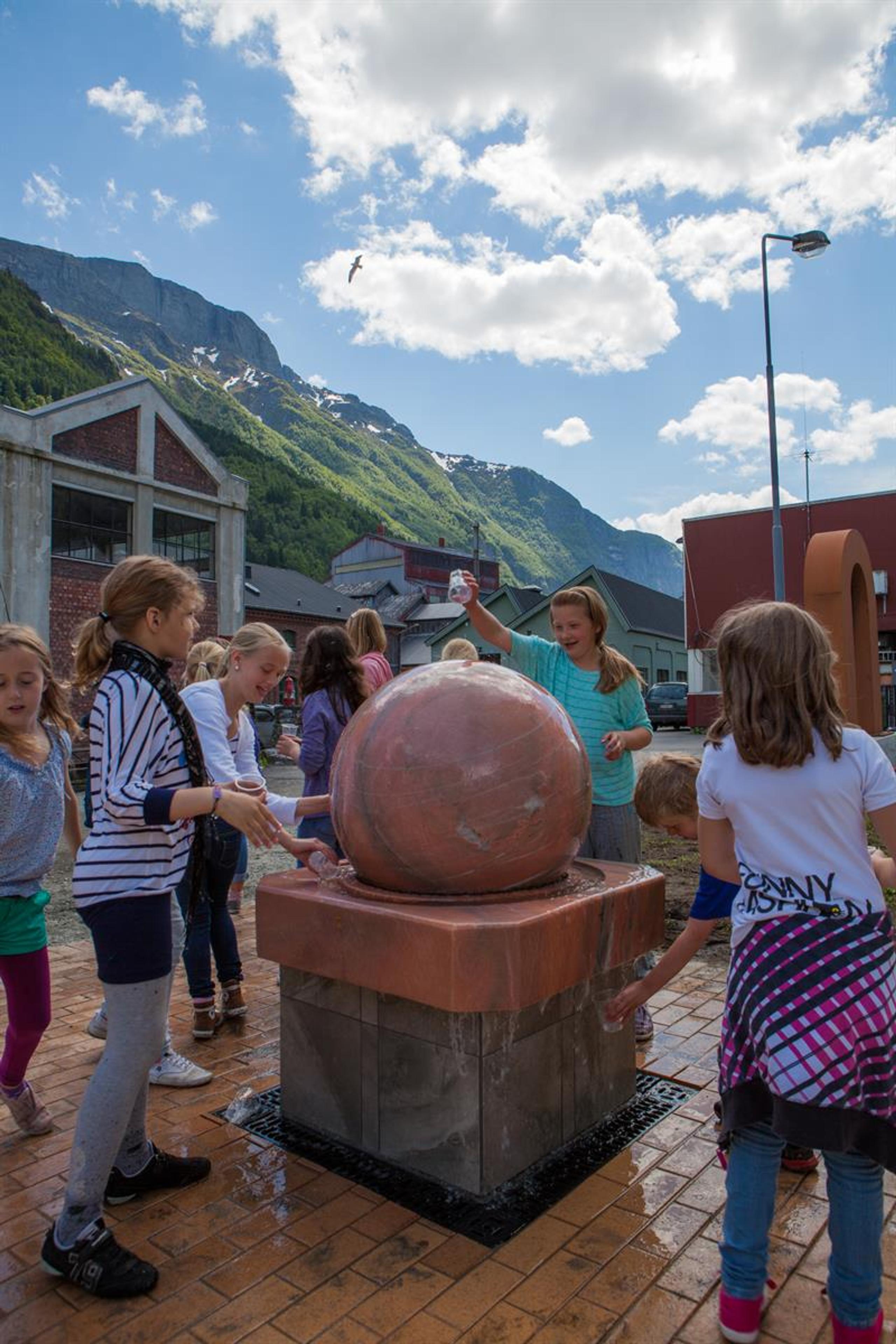 Born leikar ved vassfontena på KraftLaben, omgitt av mektige fjell i Hardanger.