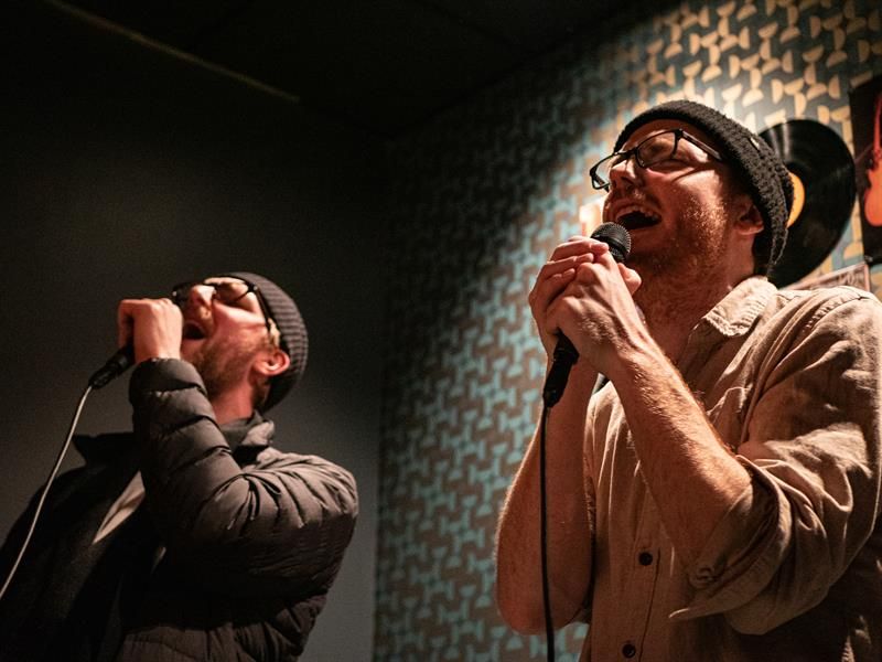 Two men sing karaoke 
