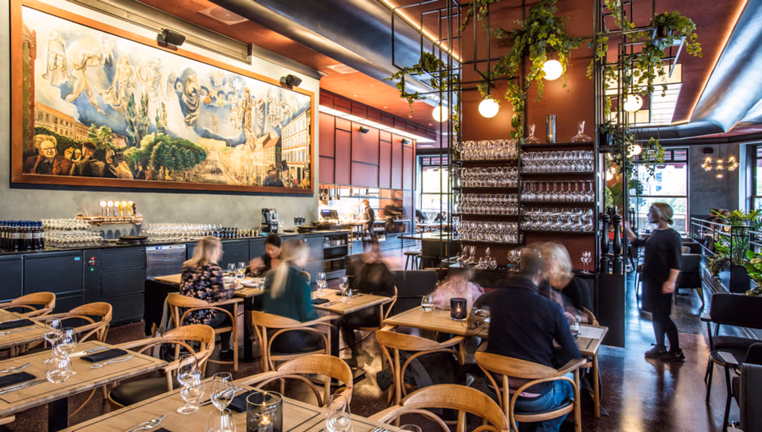 Large painting on the wall, many small tables and chairs.