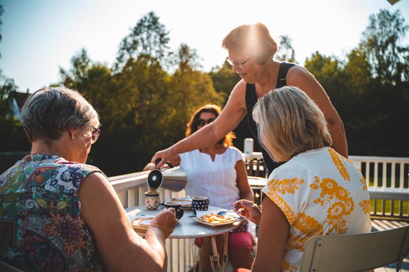 Three women are being served coffee