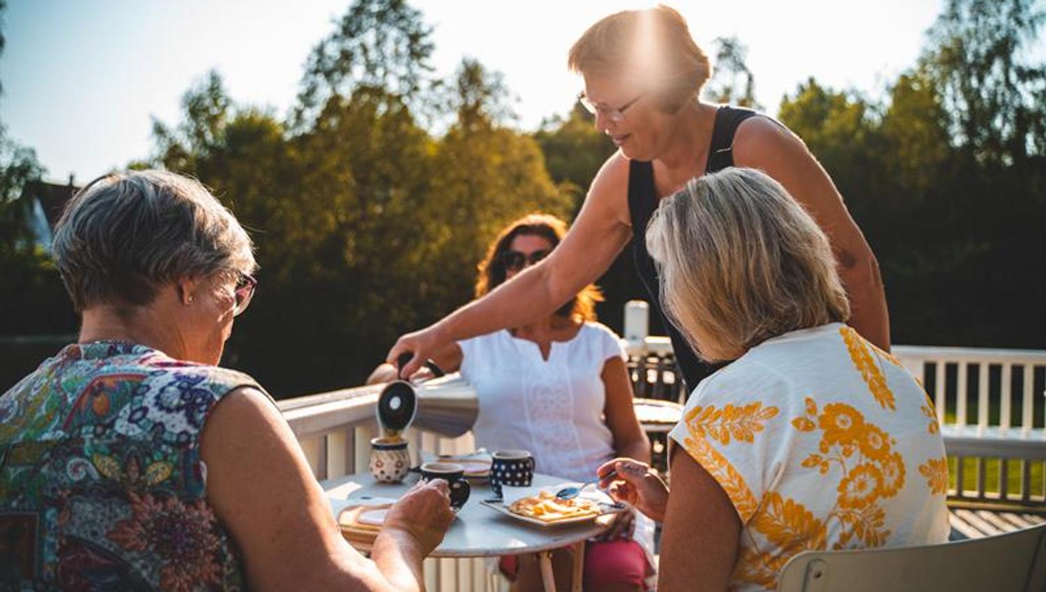 Three women are being served coffee