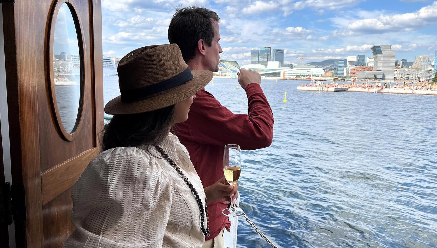 Two people on a boat looking towards Oslo