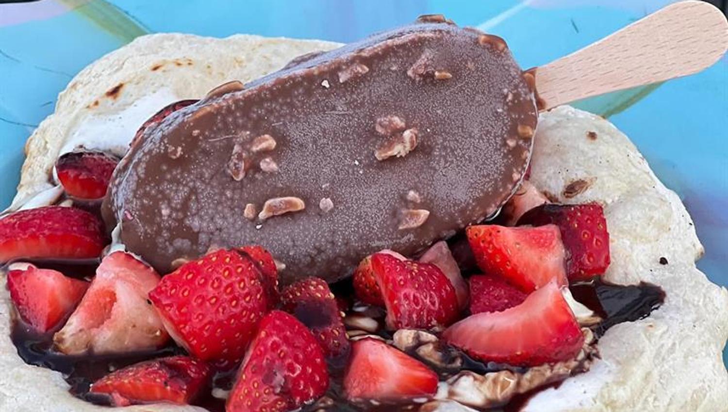 Isdessert med sjokoladeis, jordbær og krem foran skiltet til Ishuset i Havna.