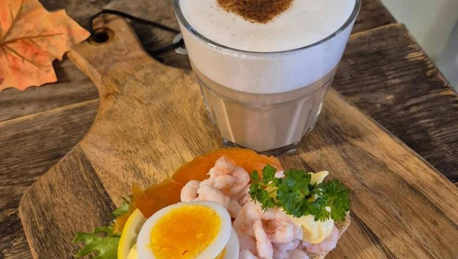 kaffe med hvitt skum og brunt hjerte, smørbrød med reker og egg