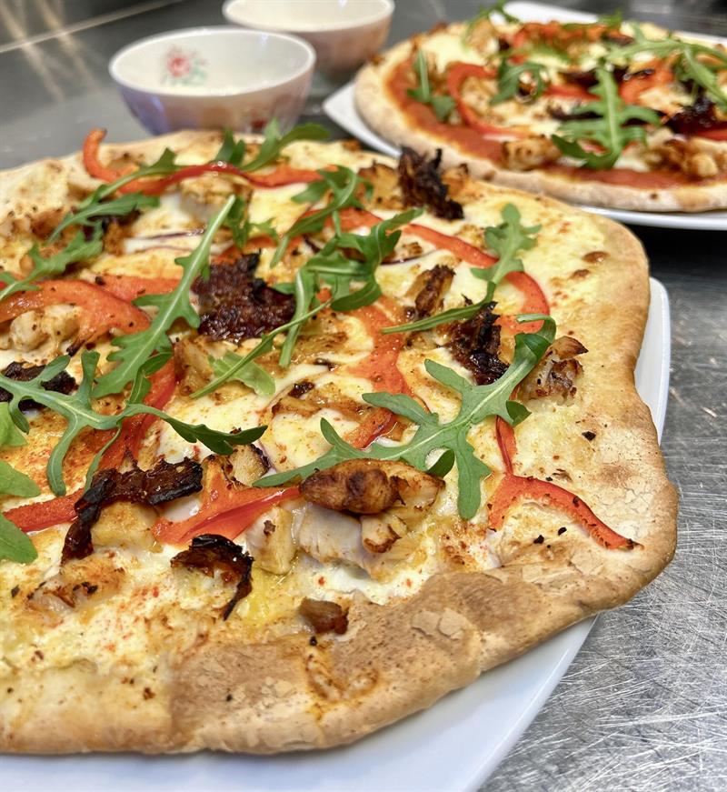 Pizza with ruccola, peppers and cheese