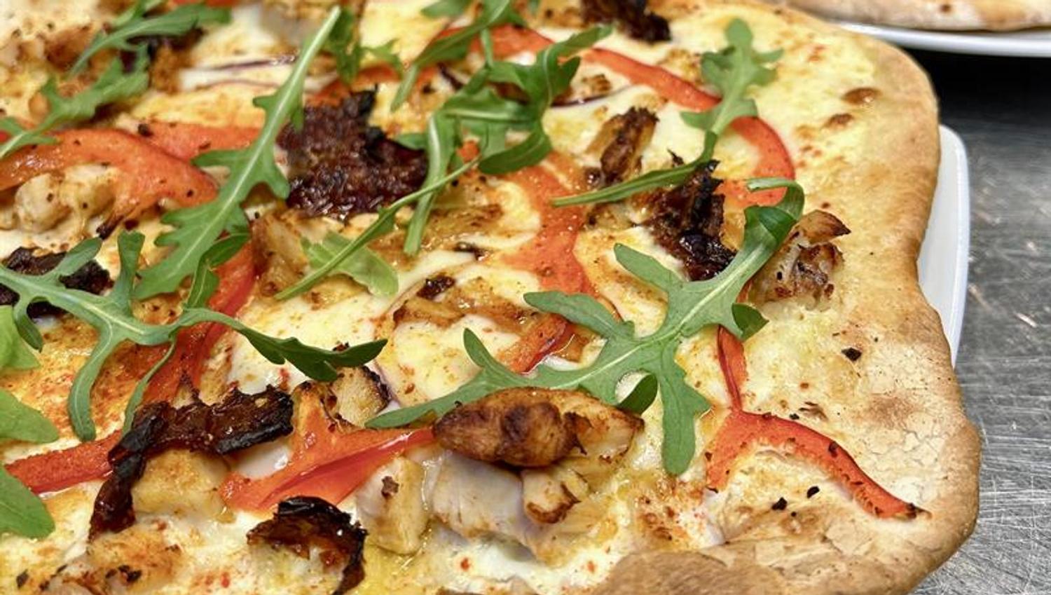 Pizza with ruccola, peppers and cheese
