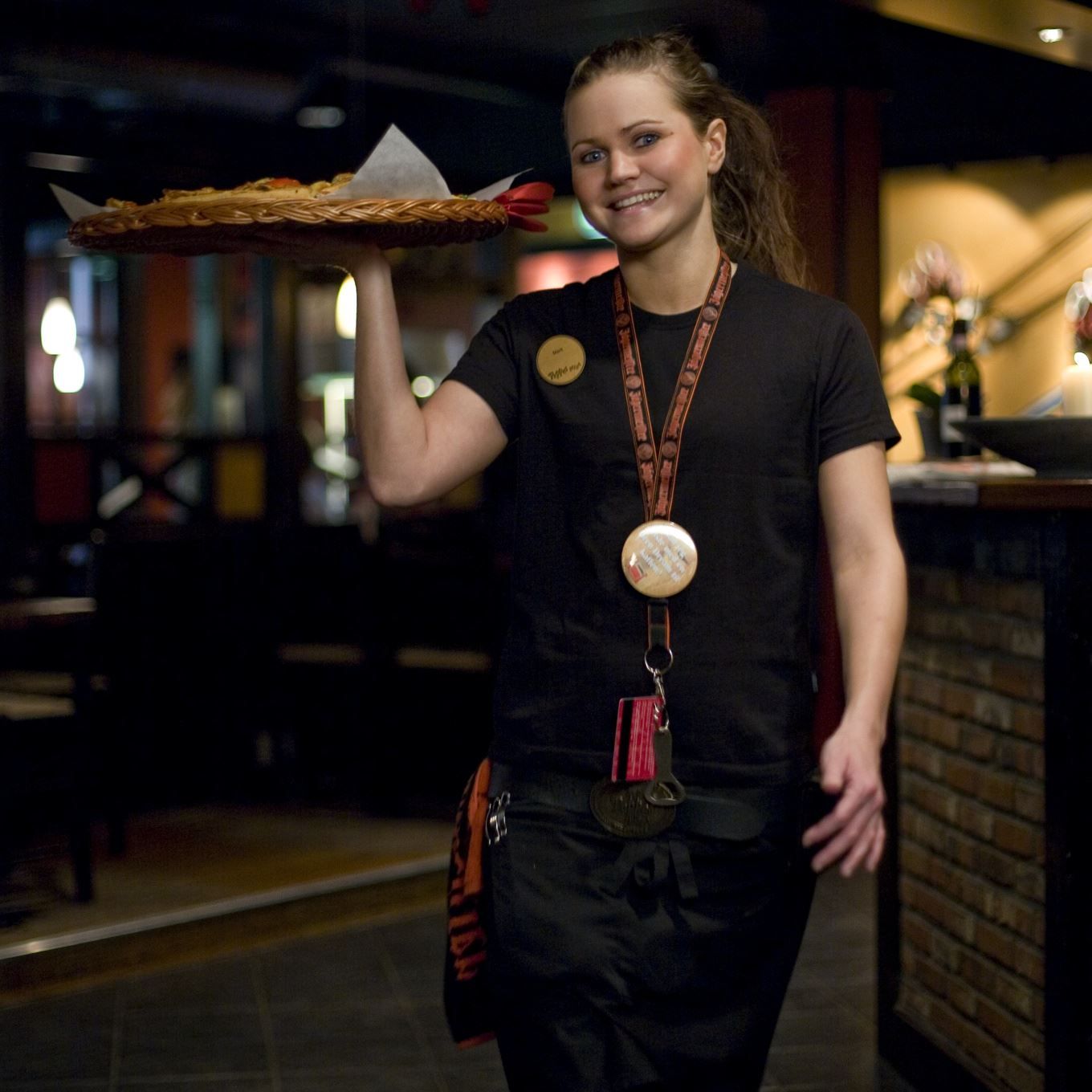 Employee holding pizza