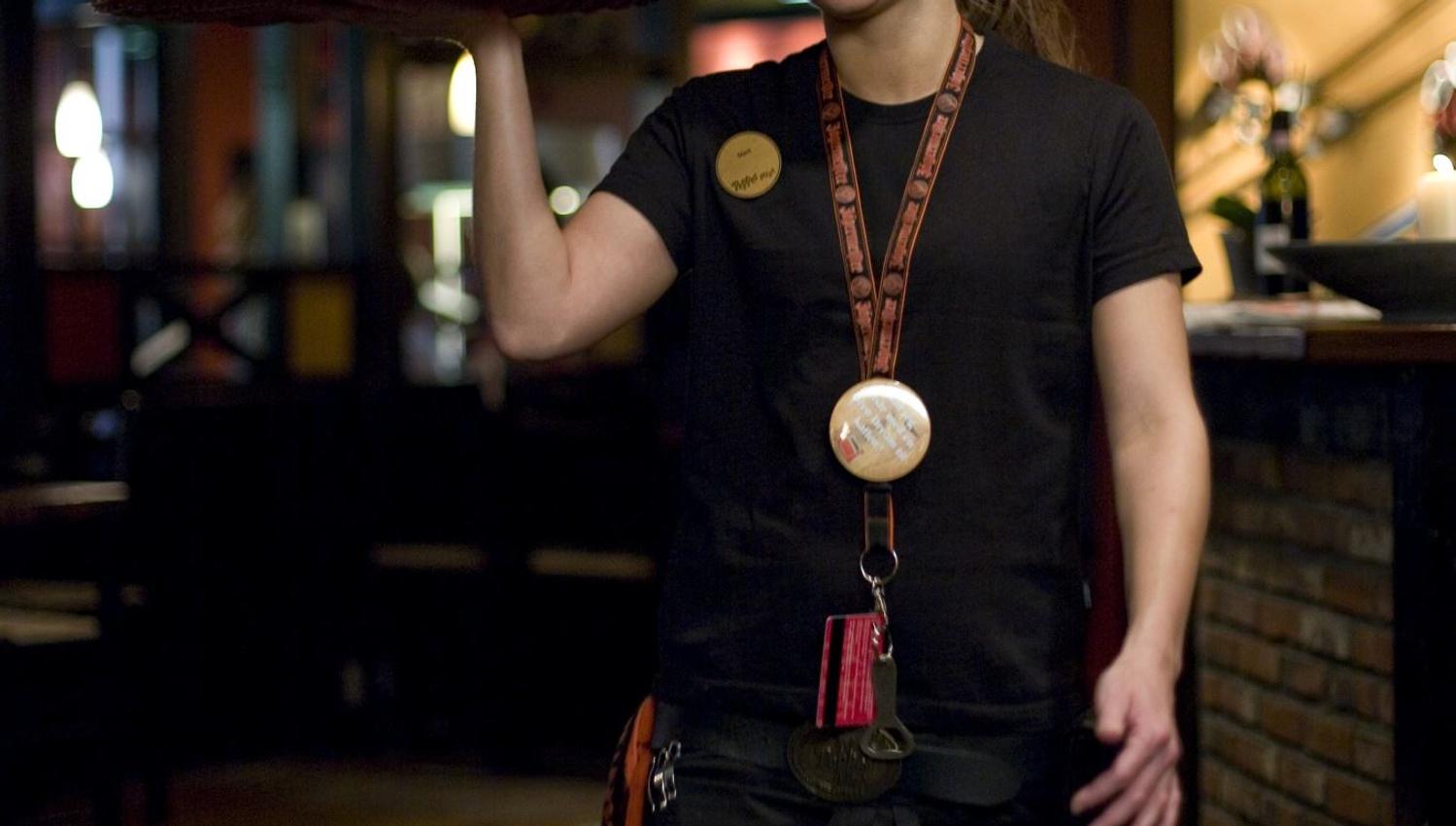 Employee holding pizza