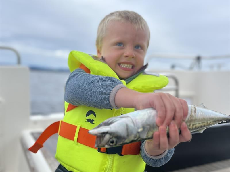 Boy with lifejacket and self caught fish