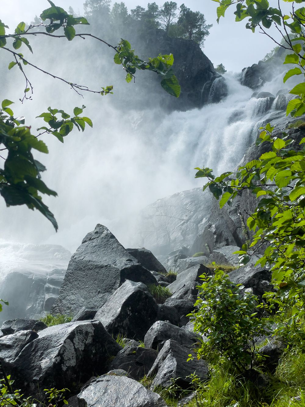 Kraftfull foss i Jordalsdalen, omgitt av grøne tre og stein – ein frisk del av turen til Jordalsnuten.