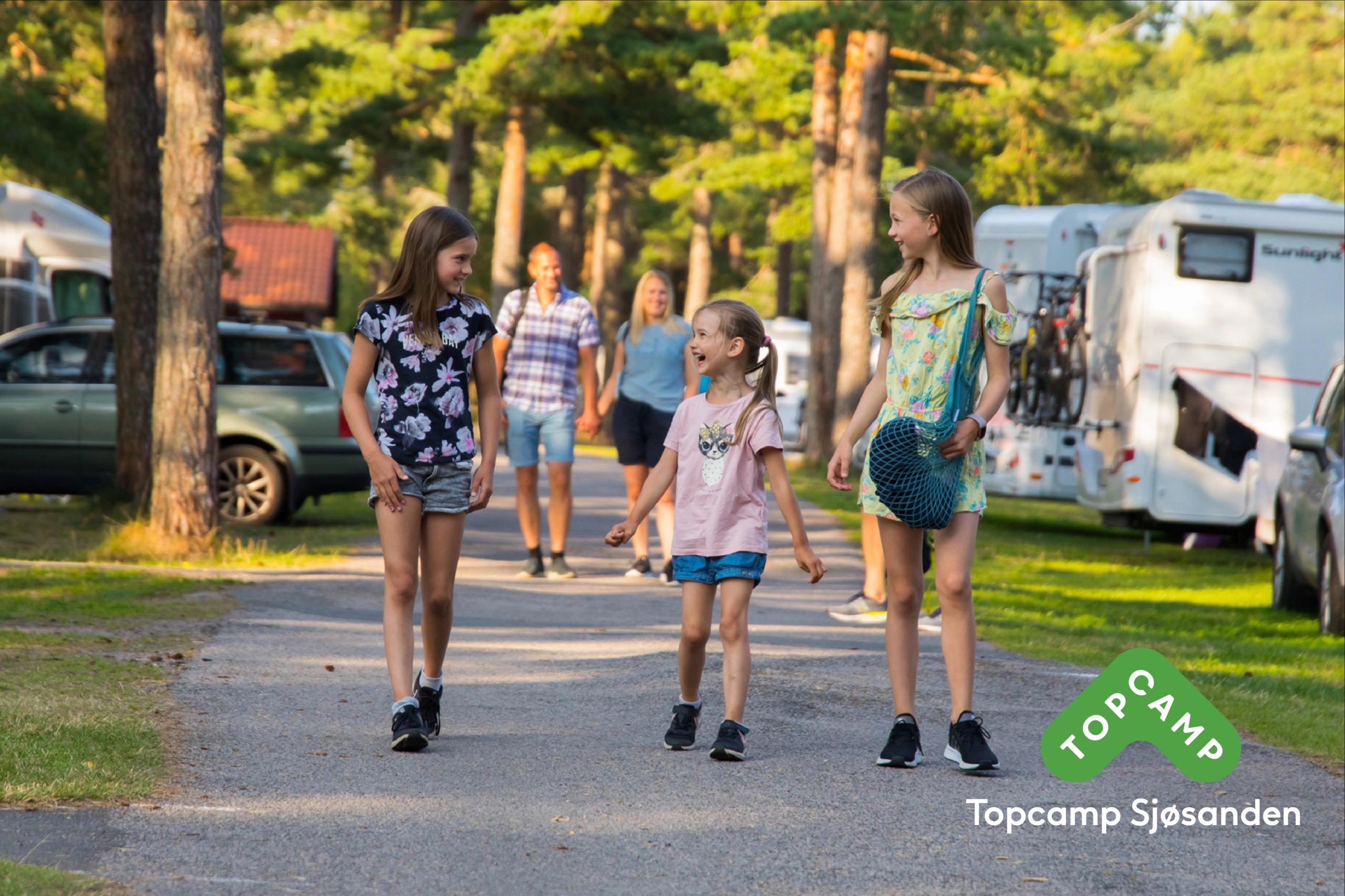 Three happy children with a couple behind them holding hands