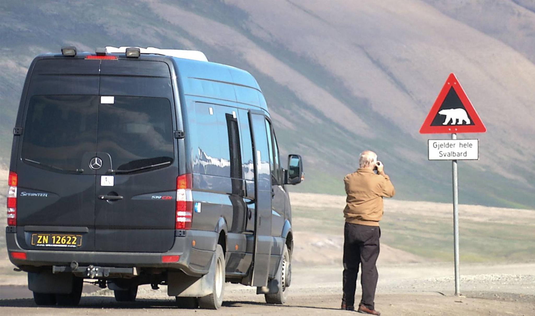 Guest taking picture of the polarbearsign in Adventdalen 