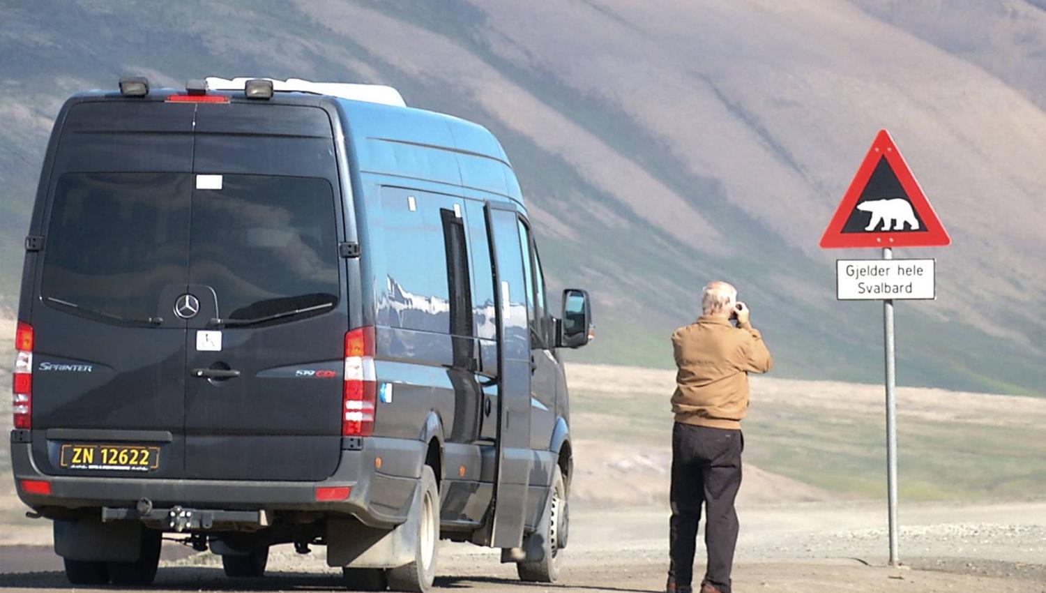 Guest taking picture of the polarbearsign in Adventdalen