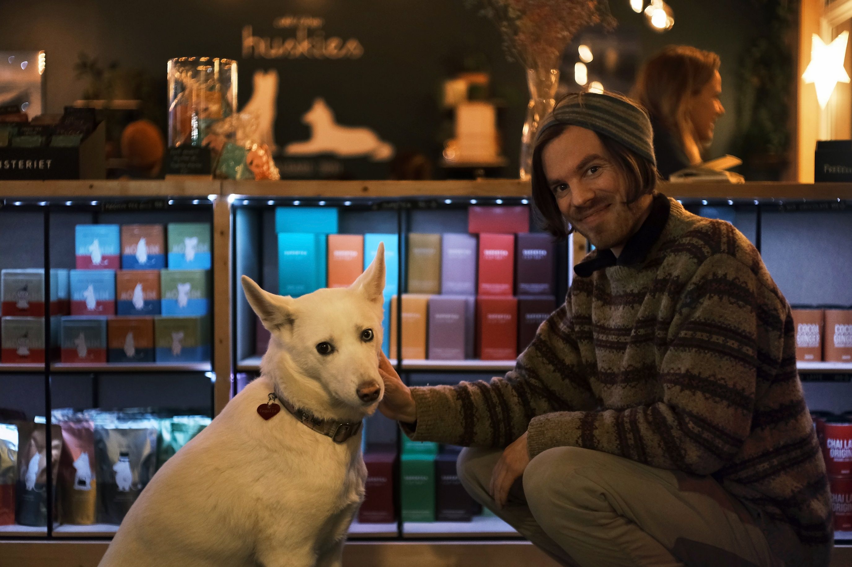 A person cuddling with a husky at Café Huskies.