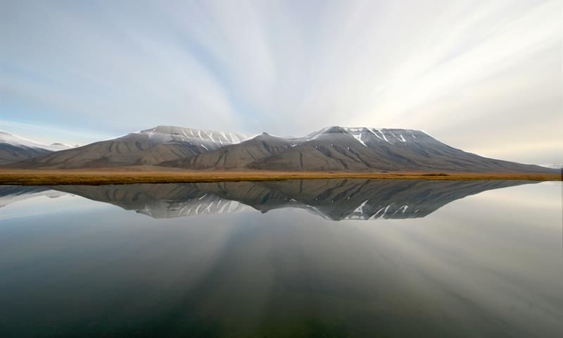 Mountains in the background mirroring in the calm sea 