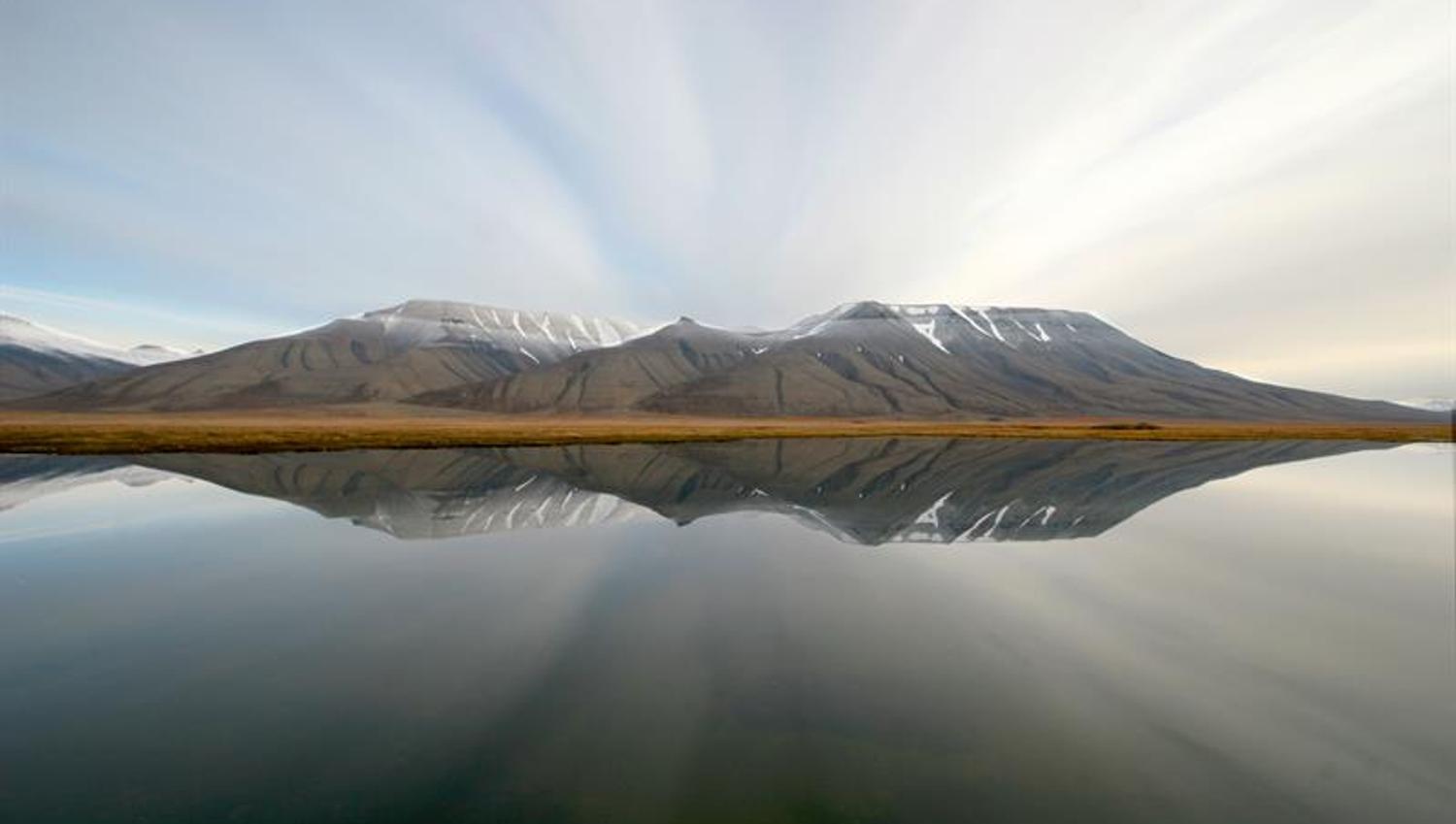 Mountains in the background mirroring in the calm sea