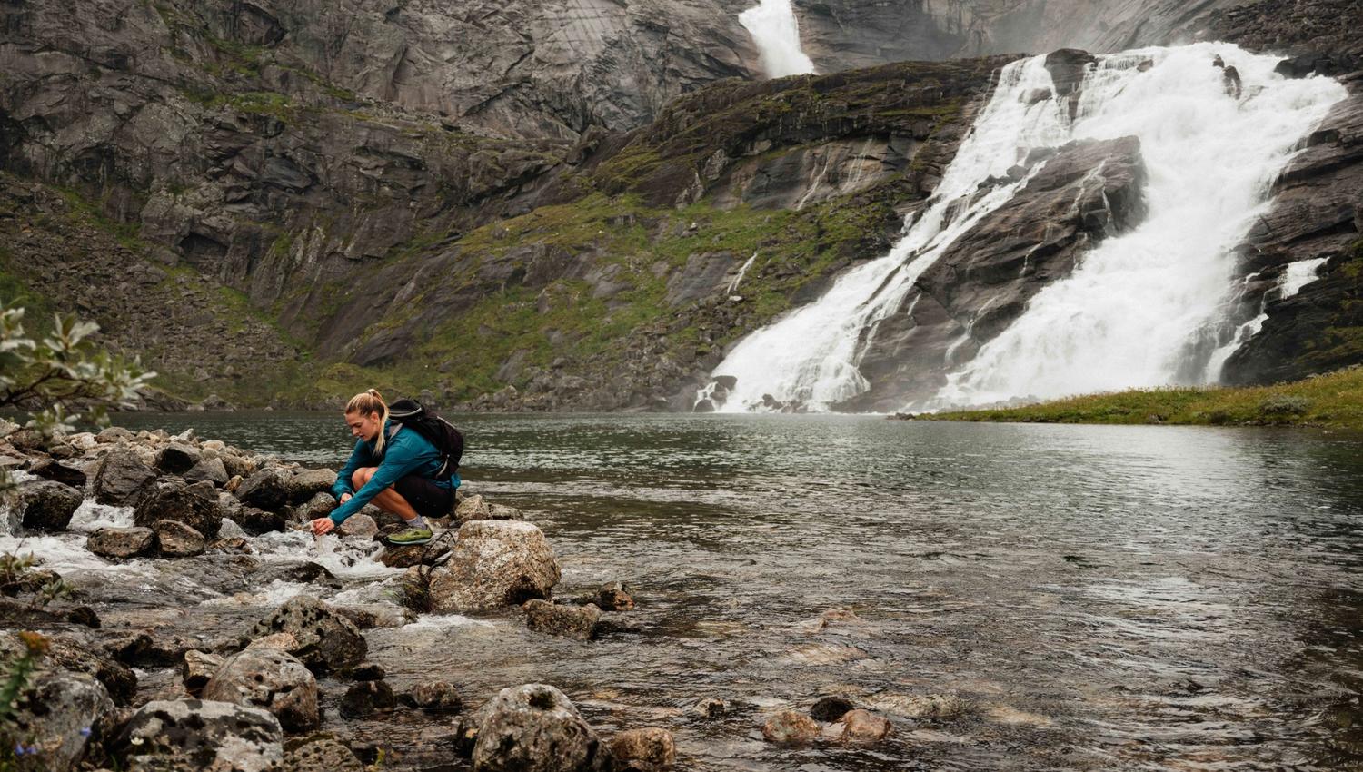 Filling up fresh mountain water from the Husedalen river – a refreshing break along the trail.