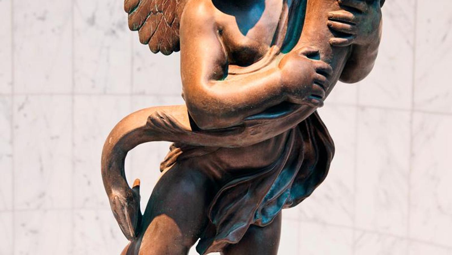 Brun statue av Eros eller en engel som holder en fisk.