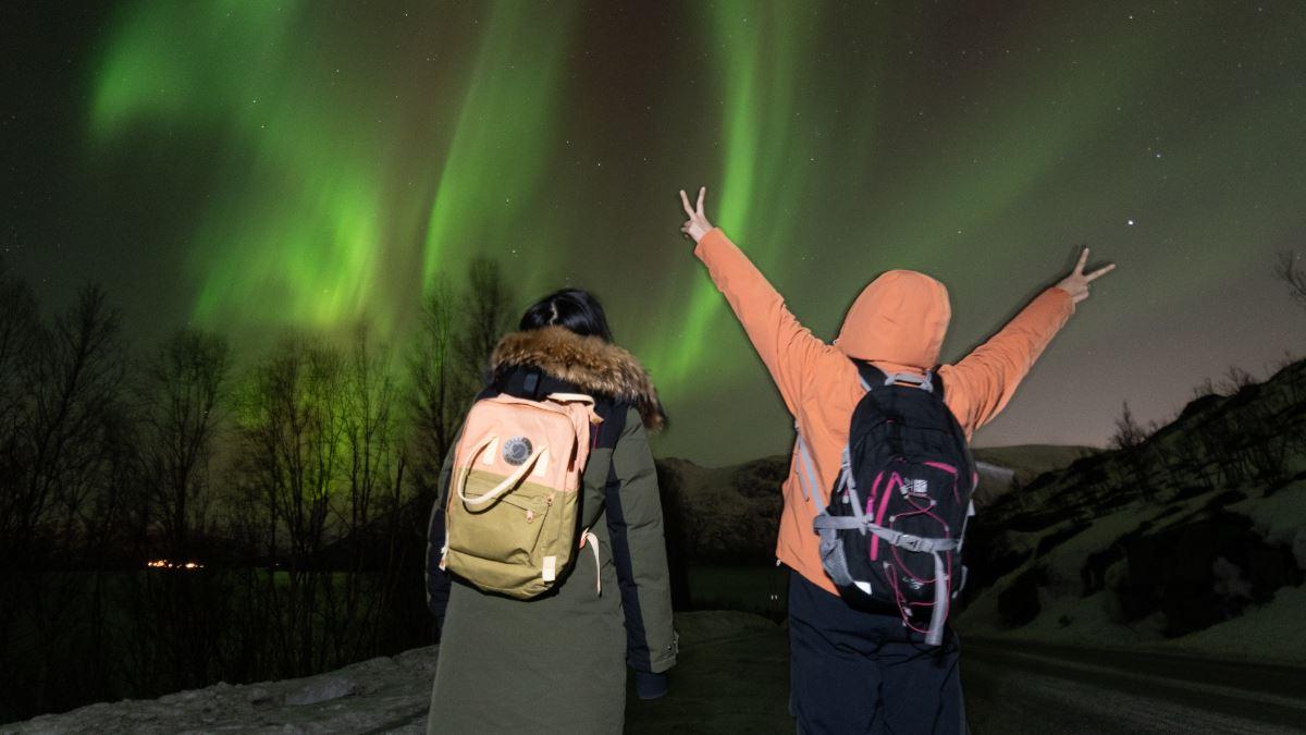 To gjester som ser på nordlyset