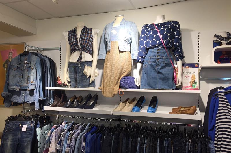 Interior with various clothes hanging on a stand.