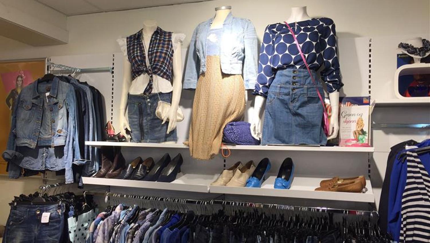 Interior with various clothes hanging on a stand.