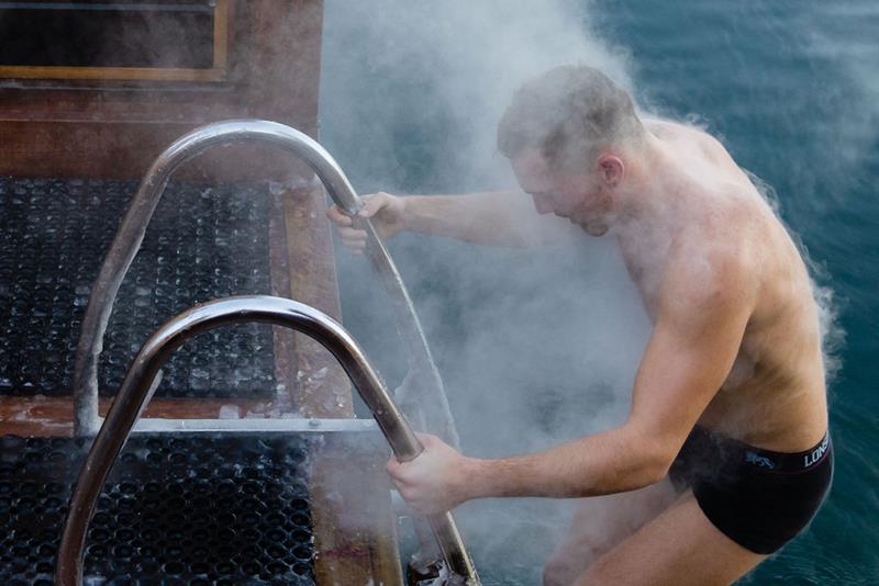 A man on his way to swim in the fjord during winter