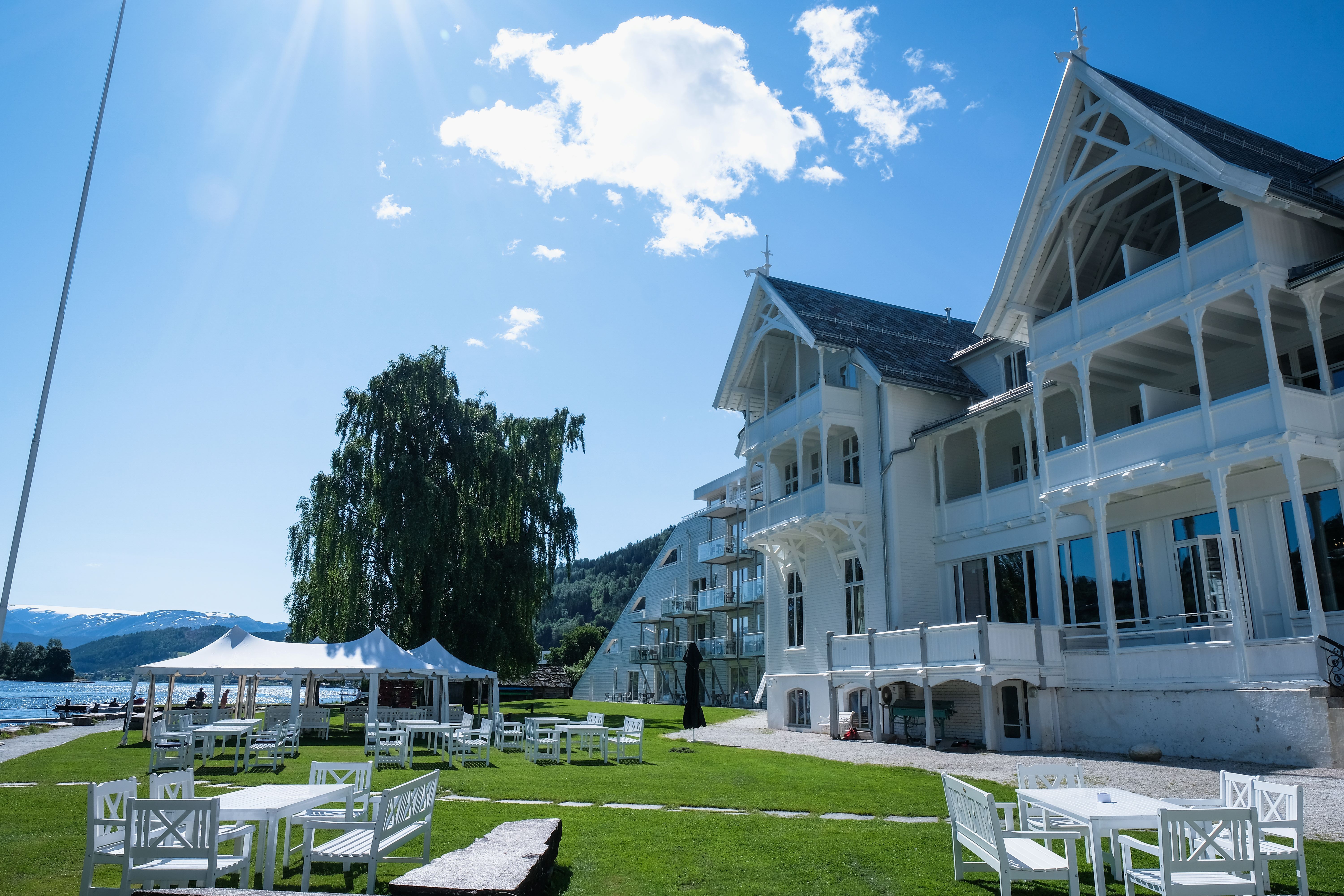 Outdoor seating area at Sjøhuset Restaurant and Pub, located at Thon Hotel in Norheimsund, with views of the Hardangerfjord and surrounding mountains 