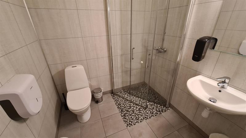 Modern bathroom with shower, toilet and sink in a cabin at Trolltunga Camping.