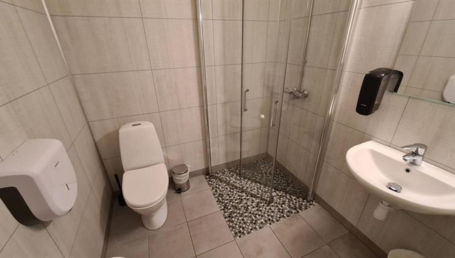 Modern bathroom with shower, toilet and sink in a cabin at Trolltunga Camping.