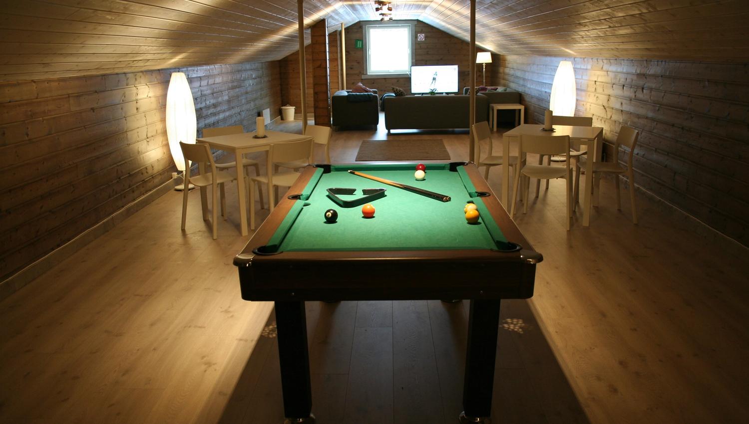 Attic lounge at Kvamseter Lodge with a pool table and seating area – ideal for cozy evenings.