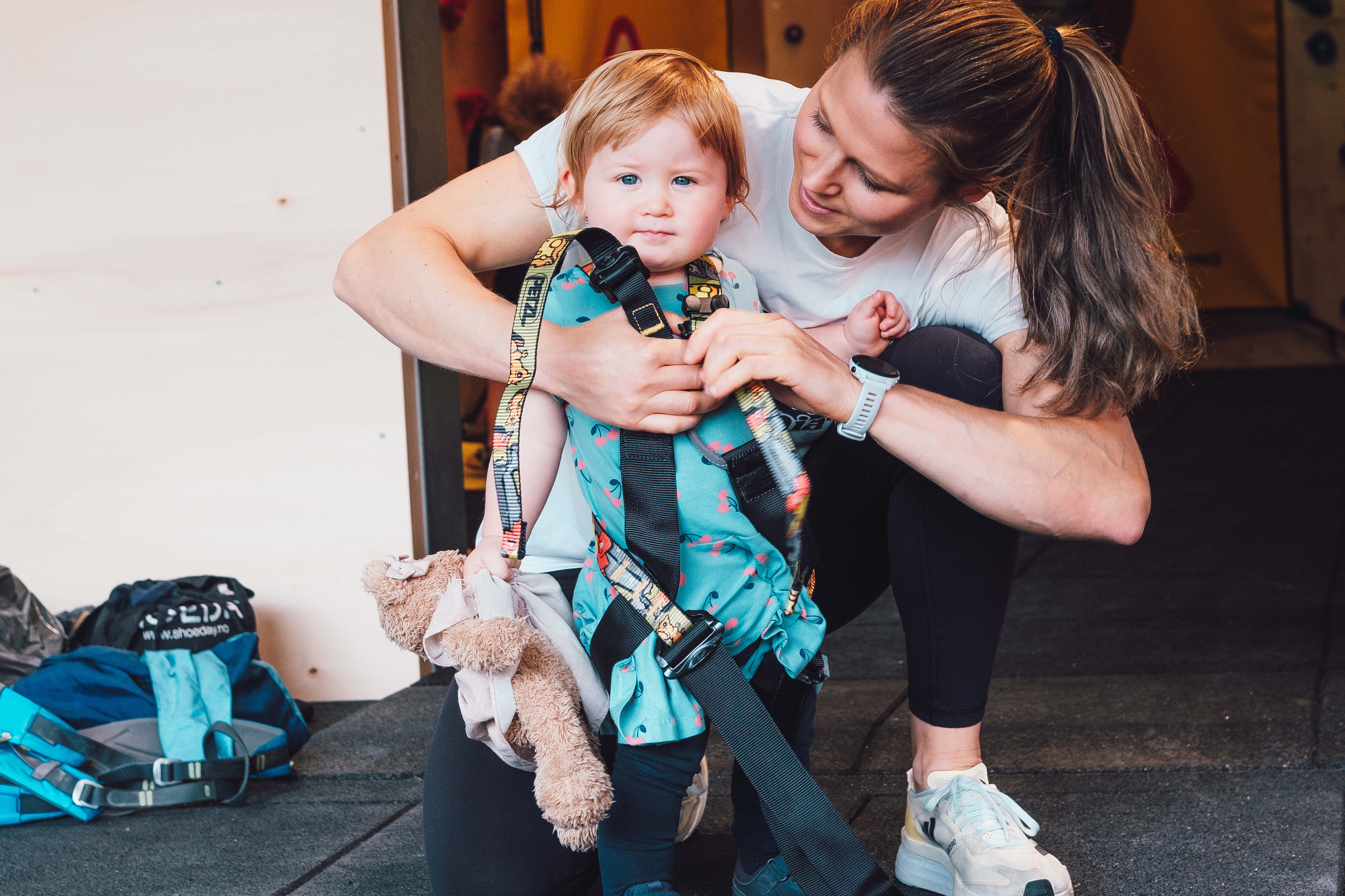 Girl getting dressed with climbing equipment