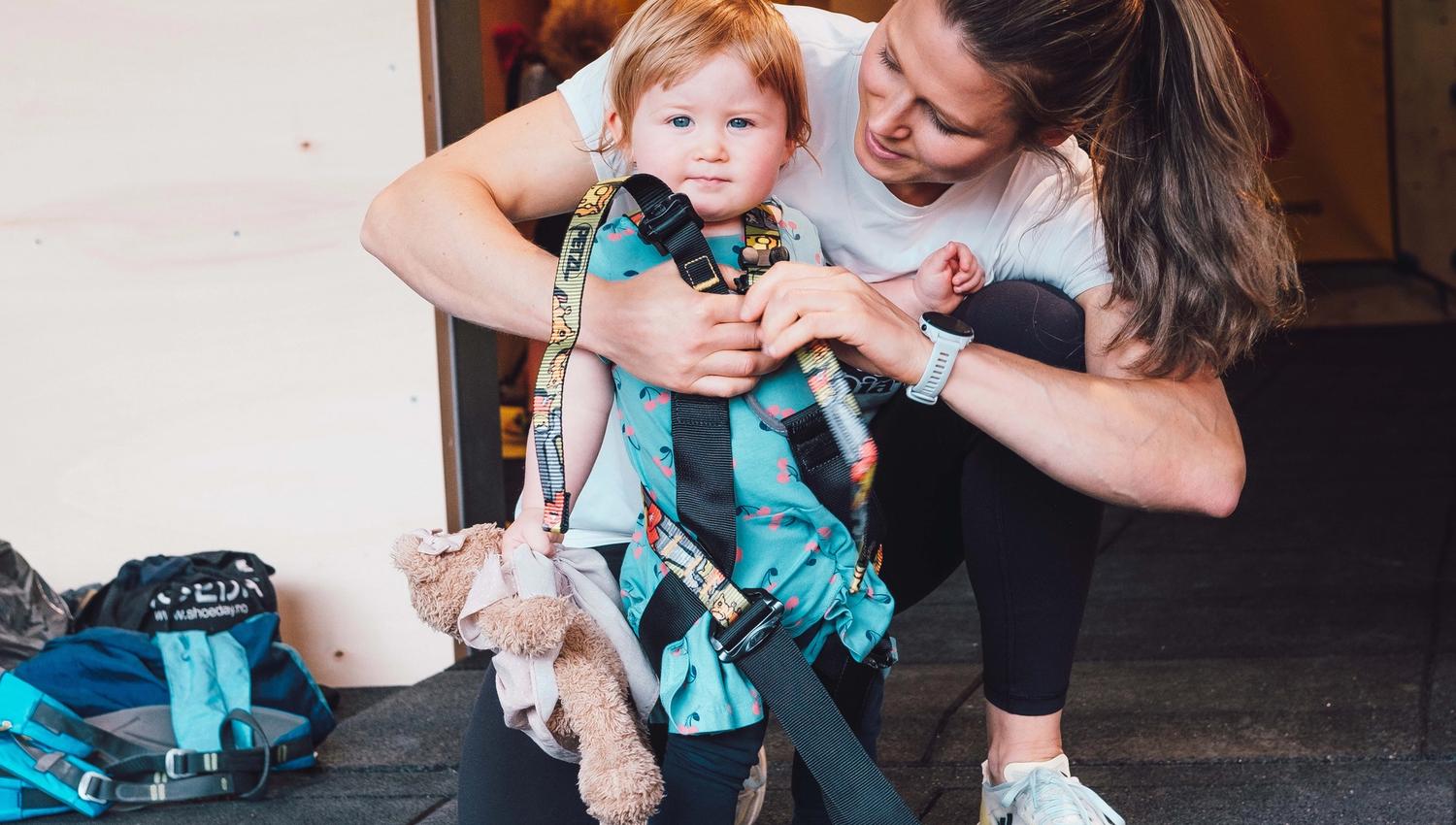 Girl getting dressed with climbing equipment