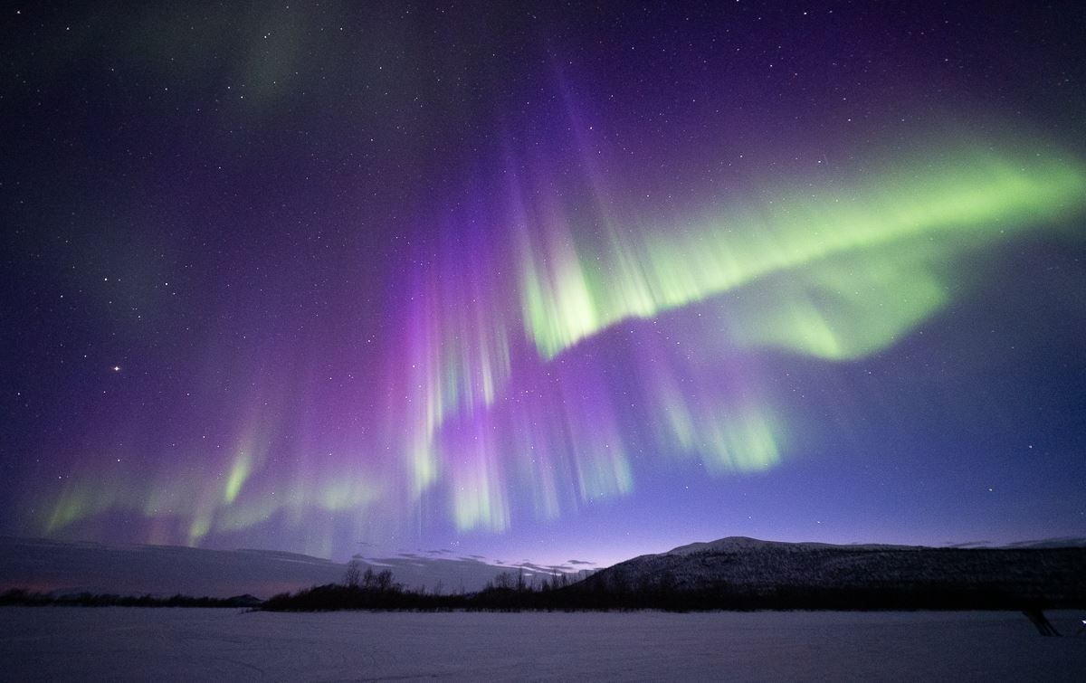 The Aurora dances in beautiful green, blue and purple overhead