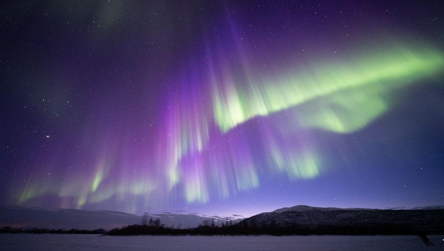 The Aurora dances in beautiful green, blue and purple overhead