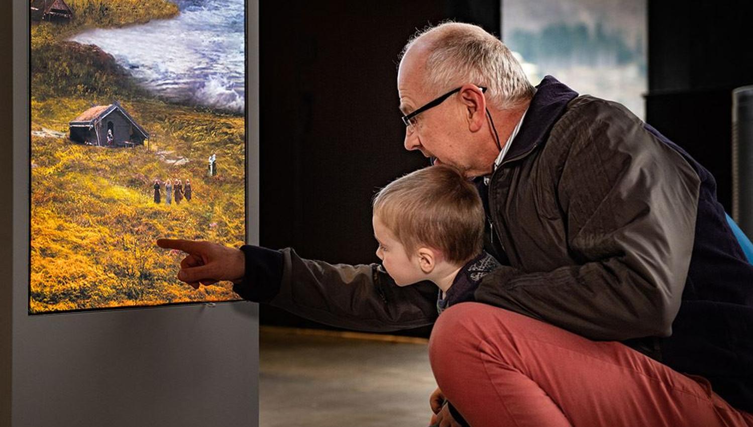 A child and grandfather exploring the exhibitions together at Sagastad Viking Center.