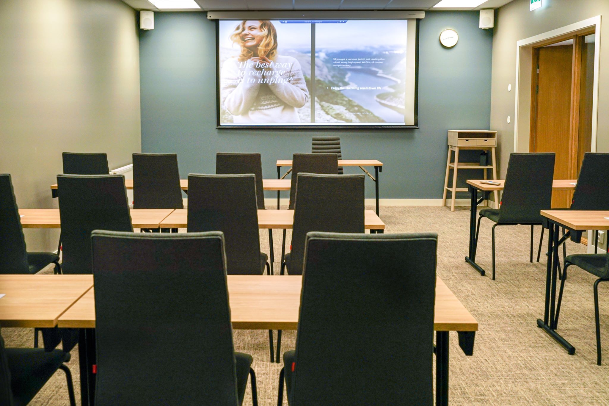 Modern meeting room with a projector and comfortable chairs.