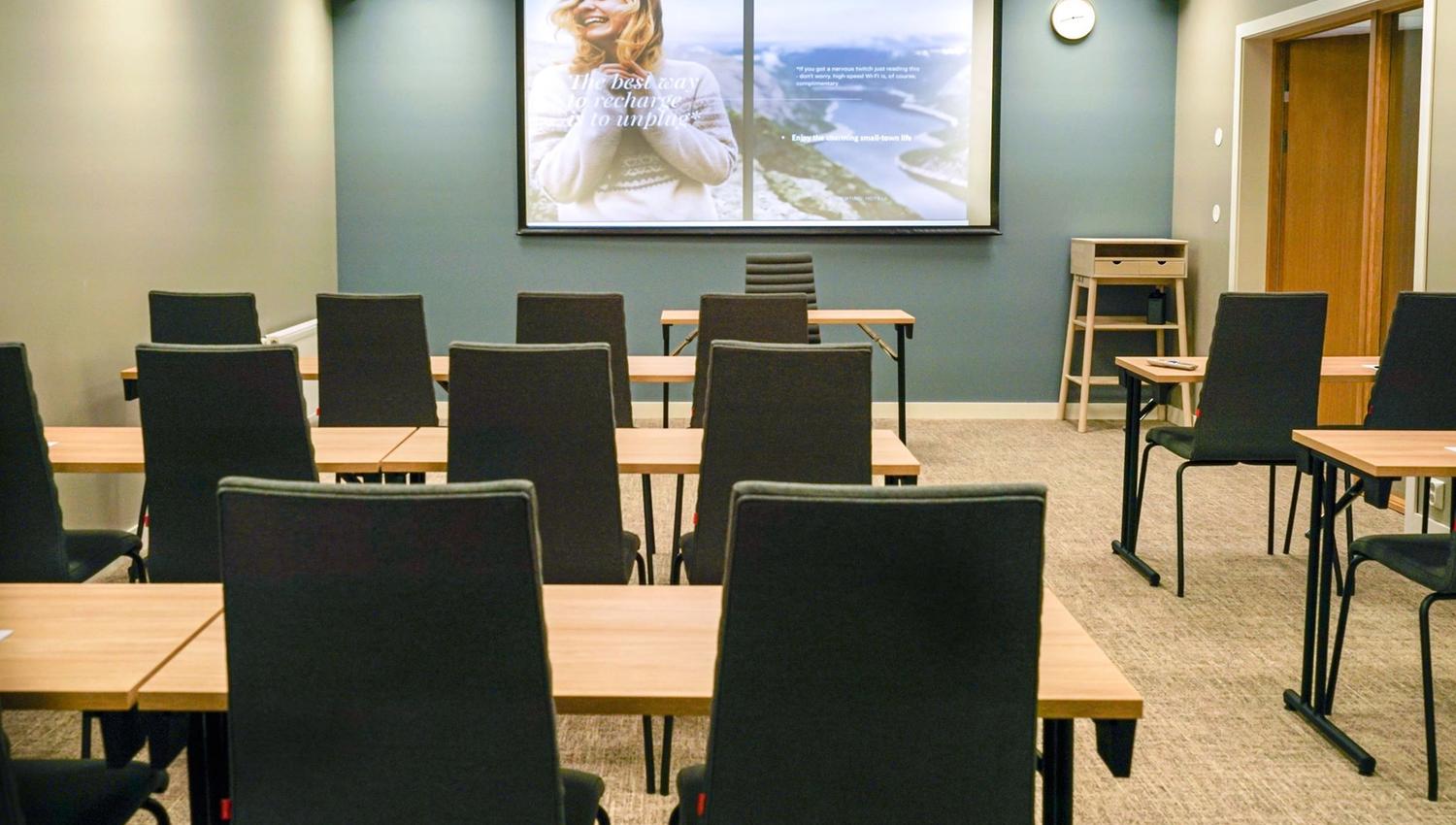 Modern meeting room with a projector and comfortable chairs.