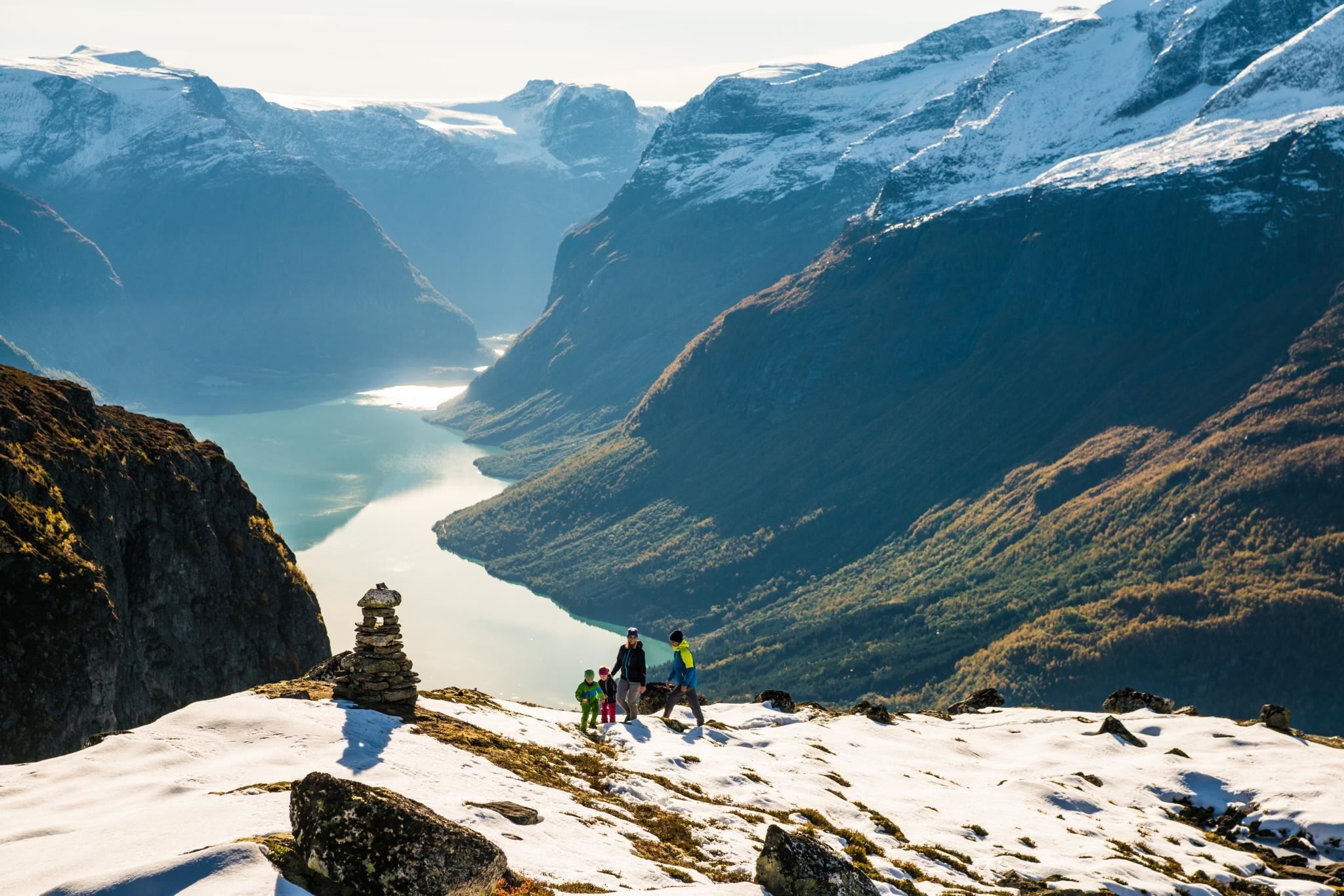 Hikers walking through the high mountain landscape at Hoven, with snow-covered peaks in the distance.